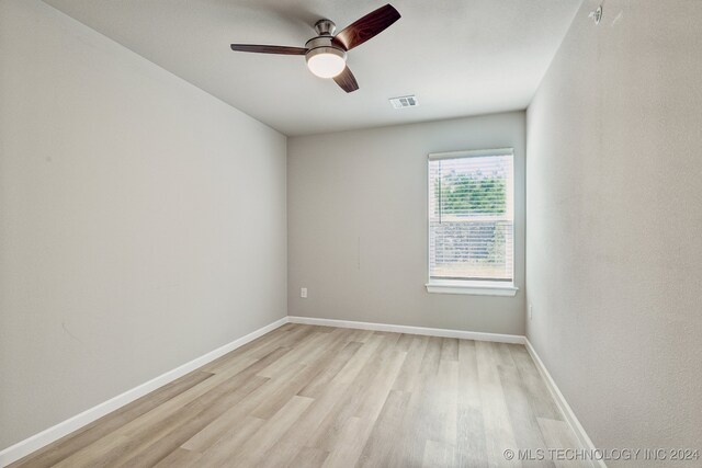 spare room with ceiling fan and light wood-type flooring