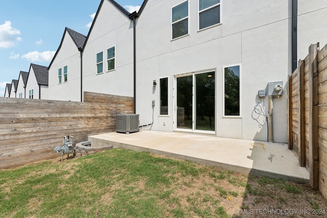 back of property featuring cooling unit, a patio area, and a lawn