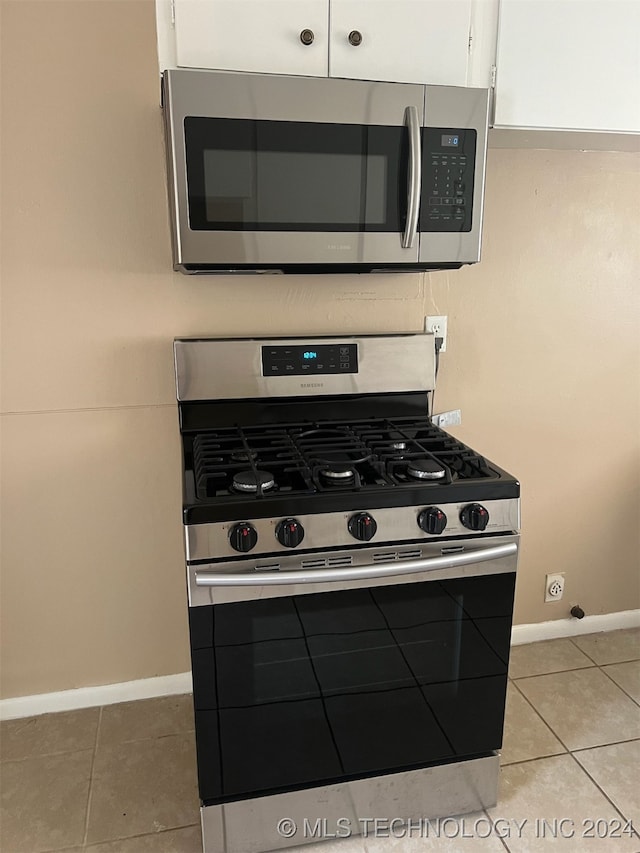 kitchen with white cabinetry, appliances with stainless steel finishes, and light tile patterned floors