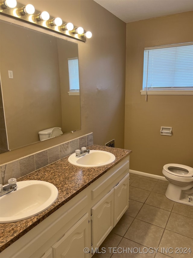 bathroom featuring dual vanity, tile patterned floors, and toilet