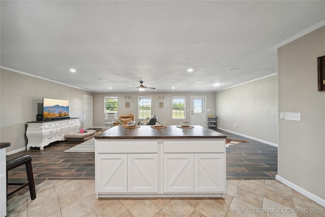 kitchen with a center island, crown molding, and light hardwood / wood-style flooring