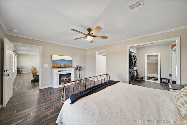 bedroom featuring a closet, ceiling fan, dark hardwood / wood-style flooring, and crown molding