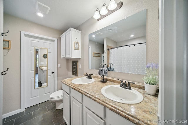 bathroom with tile patterned floors, vanity, toilet, and walk in shower