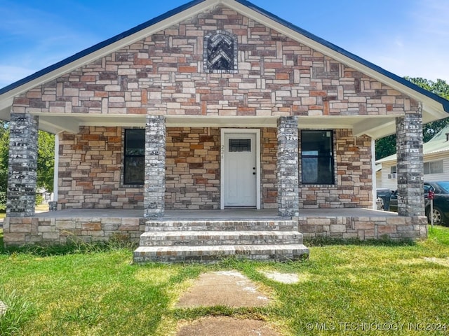 view of front of house with a porch and a front yard