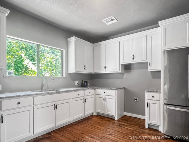 kitchen featuring sink, stainless steel refrigerator, white cabinetry, and dark wood-type flooring