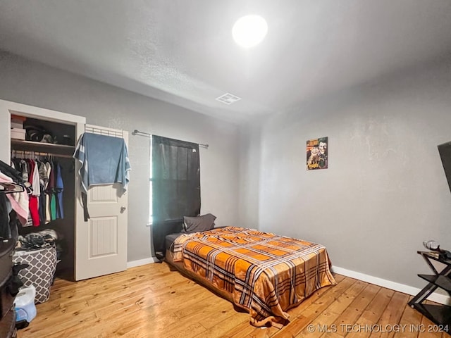 bedroom with light hardwood / wood-style flooring and a closet