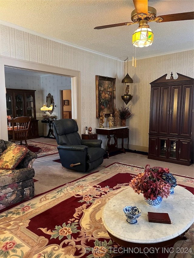 carpeted living room featuring ceiling fan, ornamental molding, and a textured ceiling