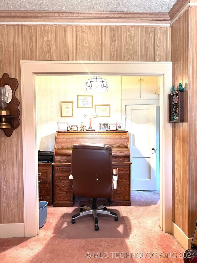 carpeted home office with ornamental molding and wood walls