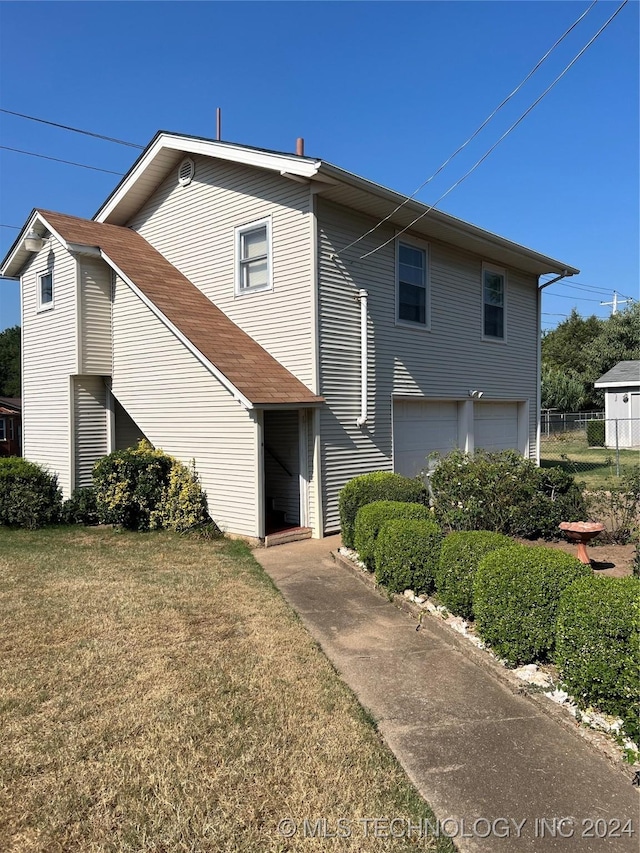 view of front of property featuring a garage and a front lawn