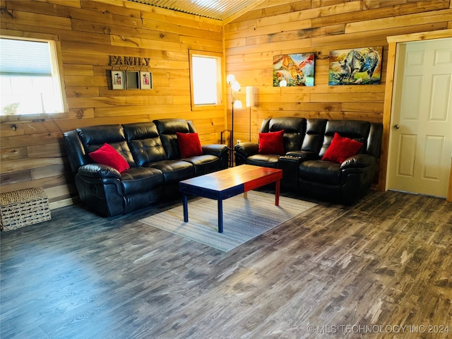 living room with wood-type flooring, vaulted ceiling, and wood walls