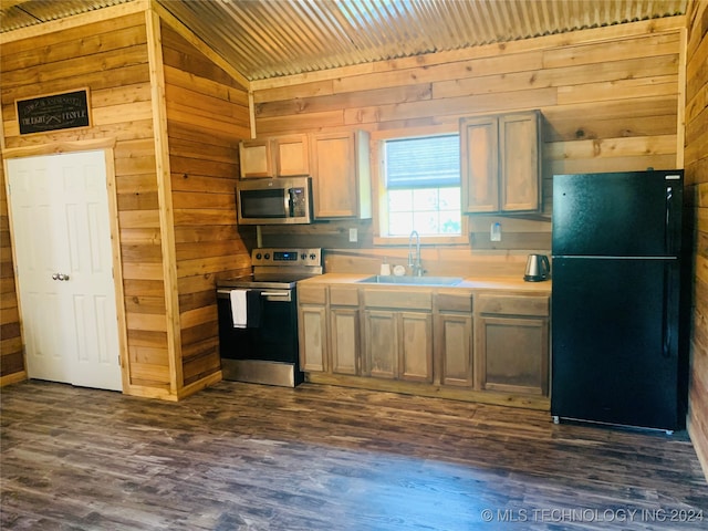 kitchen with lofted ceiling, dark hardwood / wood-style floors, appliances with stainless steel finishes, wooden walls, and sink