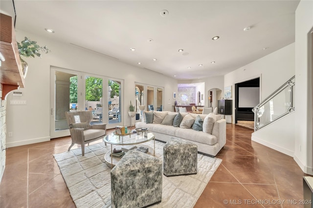 tiled living area with arched walkways, stairway, baseboards, and recessed lighting