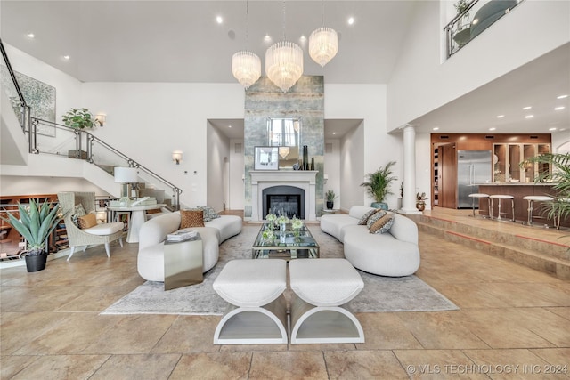 living room featuring stairway, a fireplace, and a towering ceiling