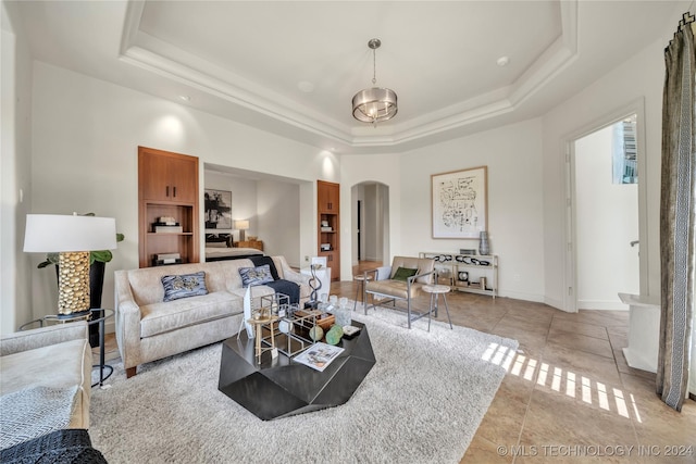 living area with arched walkways, light tile patterned flooring, a raised ceiling, and baseboards