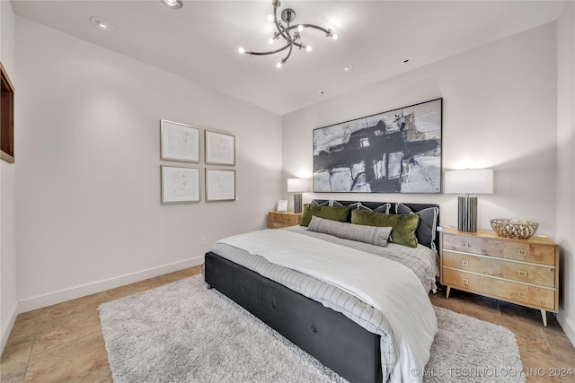 bedroom with an inviting chandelier and baseboards