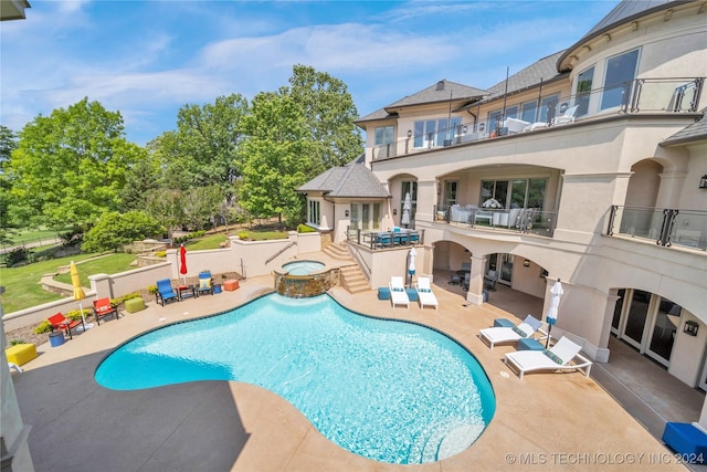 view of swimming pool with a patio area, fence, and a pool with connected hot tub