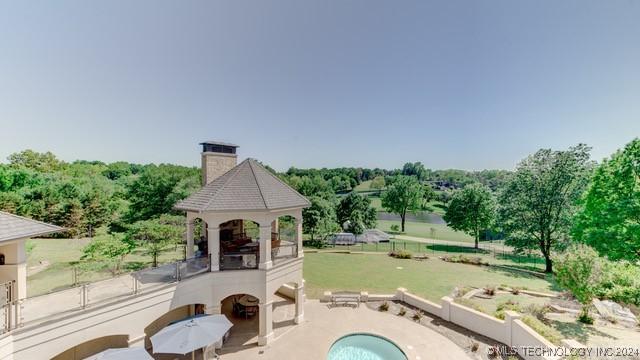 view of pool featuring a yard, exterior fireplace, a patio area, and fence