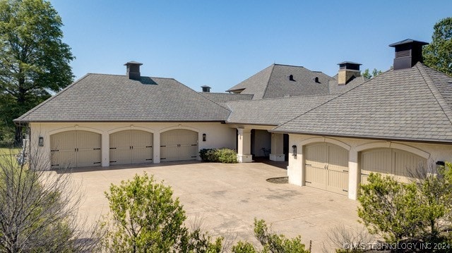 view of front of house featuring driveway, an attached garage, and stucco siding