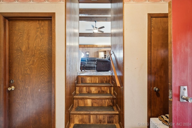 stairs featuring ceiling fan