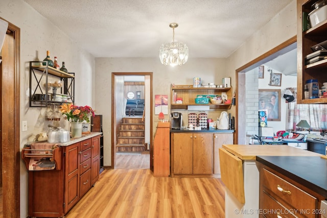 kitchen with a textured ceiling, butcher block countertops, a chandelier, and light hardwood / wood-style floors