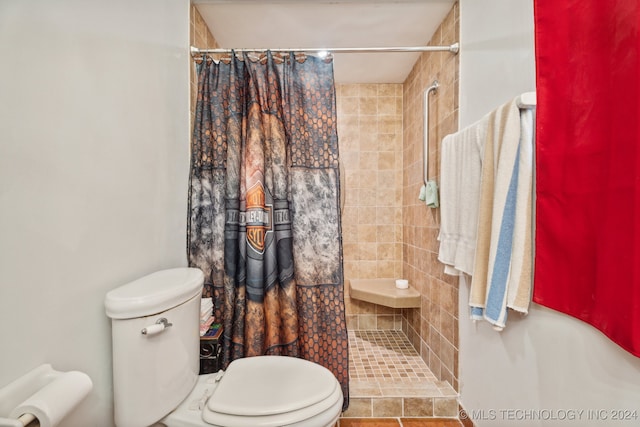 bathroom featuring toilet, a shower with curtain, and tile patterned flooring