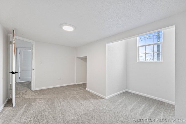 carpeted empty room featuring a textured ceiling