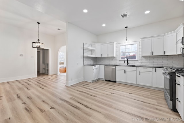 kitchen featuring pendant lighting, white cabinets, appliances with stainless steel finishes, and light hardwood / wood-style flooring