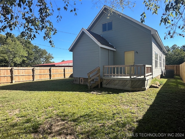 rear view of property featuring a deck, a lawn, and central air condition unit