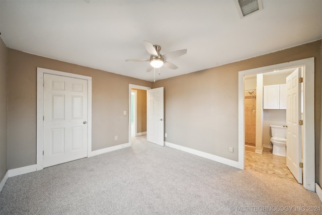 unfurnished bedroom featuring ensuite bathroom, ceiling fan, light carpet, and a closet