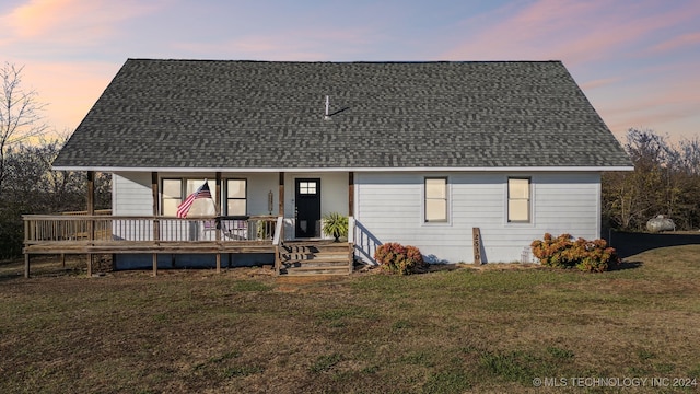 view of front facade featuring covered porch and a yard