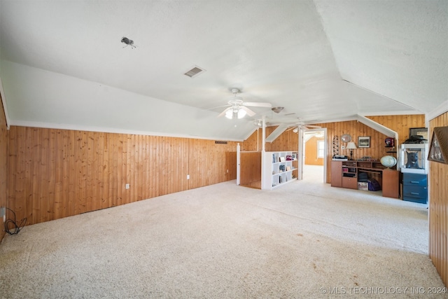 additional living space featuring carpet, wooden walls, ceiling fan, and lofted ceiling