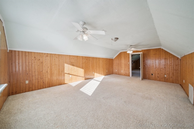 bonus room with wood walls, lofted ceiling, and carpet floors