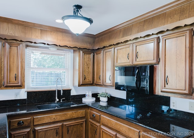 kitchen featuring sink, hanging light fixtures, and dark stone counters