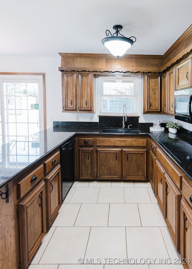 kitchen featuring a healthy amount of sunlight, sink, light tile patterned floors, and black appliances