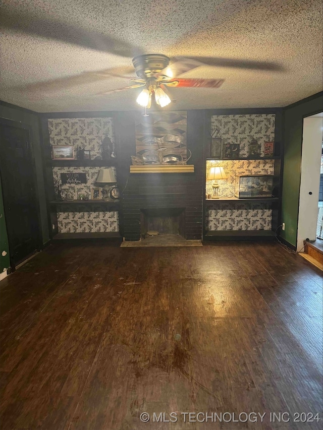 unfurnished living room featuring ceiling fan, dark wood-type flooring, a fireplace, and a textured ceiling