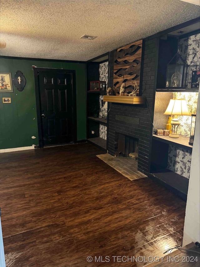 unfurnished living room featuring hardwood / wood-style floors, a fireplace, and a textured ceiling