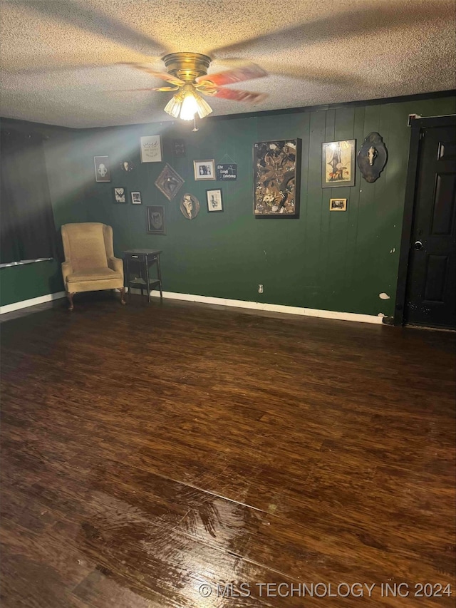 interior space featuring ceiling fan, wood-type flooring, and a textured ceiling