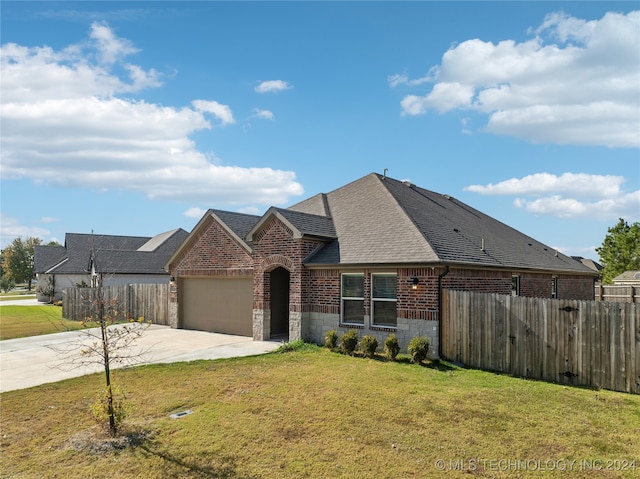 view of front of property with a garage and a front lawn