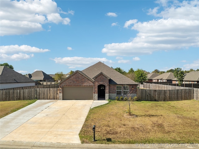 view of front of home with a front yard and a garage