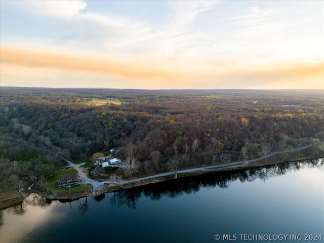 aerial view at dusk featuring a water view