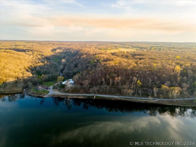 aerial view at dusk featuring a water view