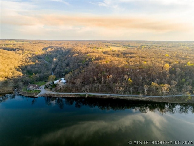 aerial view at dusk featuring a water view