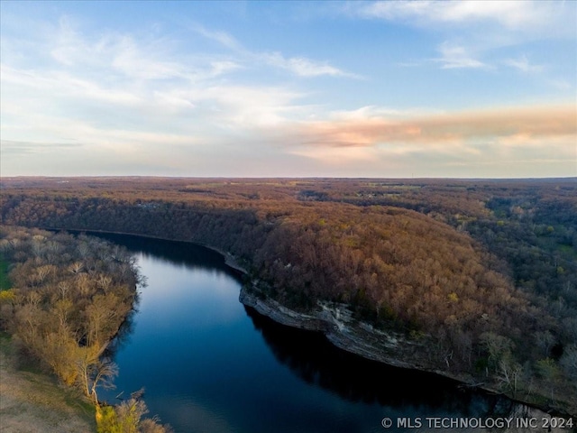 aerial view at dusk featuring a water view