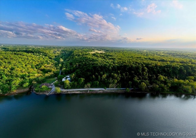 aerial view at dusk featuring a water view