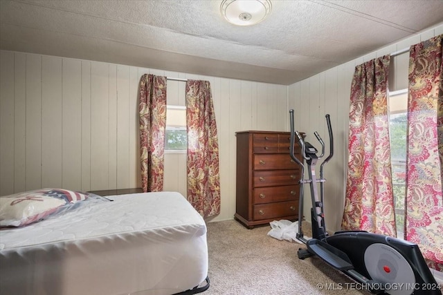 carpeted bedroom with wooden walls