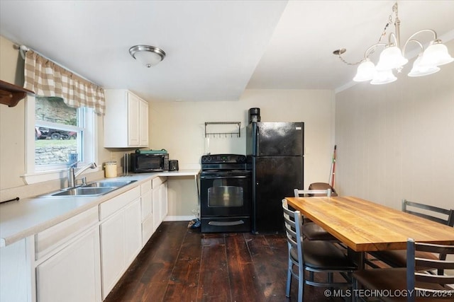 kitchen with white cabinetry, sink, dark hardwood / wood-style flooring, a notable chandelier, and black appliances