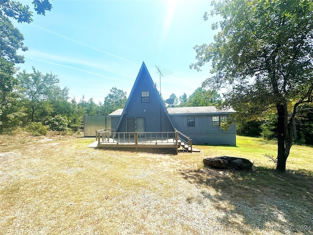 rear view of property with a lawn and a deck