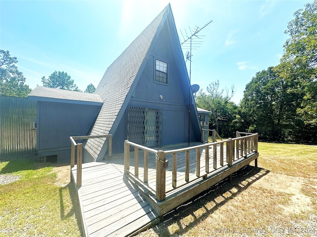 back of house featuring a wooden deck and a yard