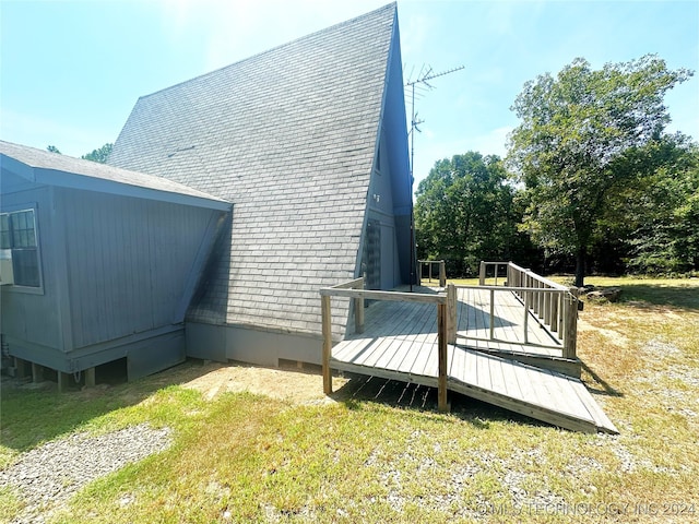 view of property exterior with a yard and a wooden deck