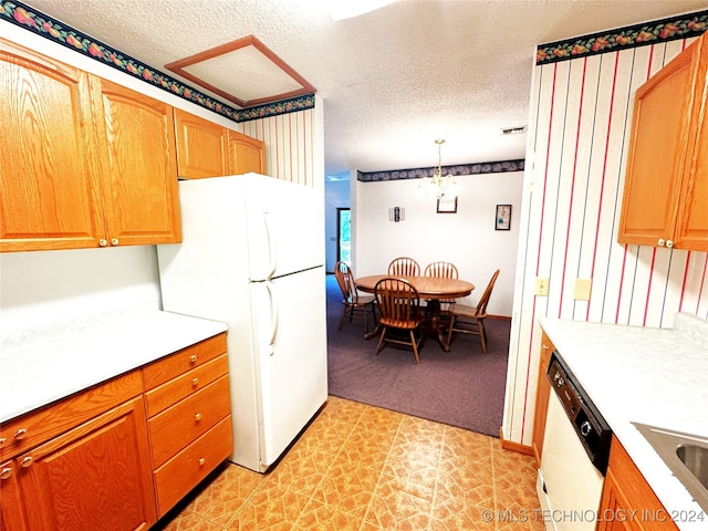 kitchen with light tile patterned floors, a textured ceiling, white appliances, and decorative light fixtures